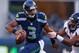 SEATTLE, WA - AUGUST 17: Quarterback Russell Wilson #3 of the Seattle Seahawks rushes against linebacker Wesley Woodyard #52 of the Denver Broncos at CenturyLink Field on August 17, 2013 in Seattle, Washington. (Photo by Otto Greule Jr/Getty Images)