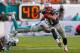 MIAMI GARDENS, FL - DECEMBER 15: Julian Edelman #11 of the New England Patriots escapes a tackle from Nolan Carroll #28 of the Miami Dolphins during a game at Sun Life Stadium on December 15, 2013 in Miami Gardens, Florida. (Photo by Mike Ehrmann/Getty