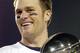Tom Brady holds the Vince Lombardi Trophy as he stands on the podium after The New England Patriots defeated The Philadelphia Eagles in Super Bowl XXXIX at Alltel Staduim in Jacksonville, Florida. (Photo by Al Messerschmidt/Getty Images)