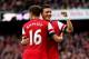 LONDON, ENGLAND - OCTOBER 19: Mesut Oezil of Arsenal (11) celebrates with Aaron Ramsey as he scores their fourth goal during the Barclays Premier League match between Arsenal and Norwich City at Emirates Stadium on October 19, 2013 in London, England. (