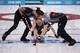 SOCHI, RUSSIA - FEBRUARY 21: Brad Jacobs (C) of Canada plays a stone as Ryan Harnden (L) and EJ Harnden (R) assist during the Men's Gold Medal match between Canada and Great Britain on day 14 of the Sochi 2014 Winter Olympics at Ice Cube Curling Center o