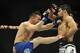 Feb 22, 2014; Las Vegas, NV, USA; Raphael Assuncao (red gloves) catches Pedro Munhoz's (blue gloves) leg as he attempted to throw a kick to Assuncao's side during their UFC bantamweight bout at Mandalay Bay. Assuncao won by unanimous decision 30-27. Man
