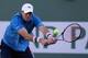 INDIAN WELLS, CA - MARCH 14: John Isner returns a backhand to Ernests Gulbis of Latvia during the BNP Paribas Open at Indian Wells Tennis Garden on March 14, 2014 in Indian Wells, California. (Photo by Jeff Gross/Getty Images)
