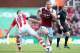 STOKE ON TRENT, ENGLAND - MARCH 15: Andy Carroll of West Ham United evades Marc Wilson of Stoke City during the Barclays Premier League match between Stoke City and West Ham United at Britannia Stadium on March 15, 2014 in Stoke on Trent, England. (Phot