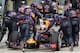 Ricciardo is pushed back down the pit lane by his mechanics.