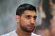 BOLTON, ENGLAND - MARCH 24: Amir Khan looks on as he tapes his hands up prior to a media workout at the Gloves Community Centre on March 24, 2014 in Bolton, England. (Photo by Alex Livesey/Getty Images)