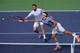 Stanislas Wawrinka and Roger Federer both reach for ball during a doubles match at Indian Wells.