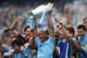 MANCHESTER, ENGLAND - MAY 11: Vincent Kompany of Manchester City lifts the Premier League trophy at the end of the Barclays Premier League match between Manchester City and West Ham United at the Etihad Stadium on May 11, 2014 in Manchester, England. (P