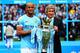 MANCHESTER, ENGLAND - MAY 11: Vincent Kompany (L) of Manchester City poses with manager Manuel Pellegrini and the Barclays Premier League trophy after the Barclays Premier League match between Manchester City and West Ham United at Etihad Stadium on May 1