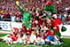 LONDON, ENGLAND - MAY 17: Arsenal players celebrate victory with mascot Gunnersauraus Rex after the FA Cup with Budweiser Final match between Arsenal and Hull City at Wembley Stadium on May 17, 2014 in London, England. (Photo by Clive Mason/Getty Images
