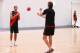 MELBOURNE, AUSTRALIA - FEBRUARY 14: Young Australian basketball player Dante Exum (L) and Joe Daniher of the Bombers handpass the ball during an Essendon Bombers AFL media session at True Value Solar Centre on February 14, 2014 in Melbourne, Australia.