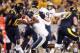 MORGANTOWN, WV - NOVEMBER 25: Geno Smith #12 of the West Virginia Mountaineers evades a tackle from Brandon Lindsey #7 of the University of Pittsburgh Panthers during the 2011 Backyard Brawl on November 25, 2011 at Mountaineer Field in Morgantown, West V