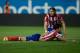 MADRID, SPAIN - APRIL 18: Filipe Luis (R) of Atletico de Madrid assists his teammate Diego Costa (L) after being tackled by Cristian Sapunaru of Elche FC during the La Liga match between Club Atletico de Madrid and Elche FC at Vicente Calderon Stadium on