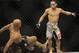 Jan 26, 2013; Chicago, IL, USA; Demetrious Johnson (black shorts) is knocked down by John Dodson (white shorts) during UFC on FOX 6 for the world flyweight championship at the United Center. Mandatory Credit: David Banks-USA TODAY Sports