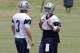Jun 17, 2014; Dallas, TX, USA; Dallas Cowboys quarterback Tony Romo (9) smiles as he hides jersey number 7 he borrowed from Caleb Hanie (not pictured) as he talks to Brandon Weeden (3) during minicamp at Cowboys headquarters at Valley Ranch. Mandatory Cre