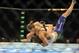 Jul 5, 2014; Las Vegas, NV, USA; Ronda Rousey (red gloves) takes down Alexis Davis (blue gloves) during the first round of a bantamweight fight at Mandalay Bay Events Center. Mandatory Credit: Stephen R. Sylvanie-USA TODAY Sports