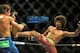 Jul 5, 2014; Las Vegas, NV, USA; Alex Caceres (blue gloves) lands a kick to Urijah Faber (red gloves) during a bantamweight fight at Mandalay Bay Events Center. Mandatory Credit: Stephen R. Sylvanie-USA TODAY Sports
