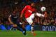 MANCHESTER, ENGLAND - MARCH 19: Patrice Evra of Manchester United competes with Leandro Salino of Olympiacos during the UEFA Champions League Round of 16 second round match between Manchester United and Olympiacos FC at Old Trafford on March 19, 2014 in