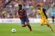 BARCELONA, SPAIN - MAY 17: Alex Song of FC Barcelona beats David Villa of Club Atletico de Madrid during the La Liga match between FC Barcelona and Club Atletico de Madrid at Camp Nou on May 17, 2014 in Barcelona, Spain. (Photo by Alex Livesey/Getty Imag