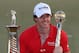 DUBAI, UNITED ARAB EMIRATES - NOVEMBER 25: Rory McIlroy of Northern Ireland with the DP World Tour Championship and The Race to Dubai trophy on the 18th green during the final roung of the DP World Tour Championship on the Earth Course at Jumeirah Golf E