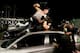 Dean Ambrose attacks Seth Rollins atop a car.