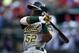 Jul 27, 2014; Arlington, TX, USA; Oakland Athletics left fielder Yoenis Cespedes (52) follows through for a two-run double against the Texas Rangers during the second inning of a baseball game at Globe Life Park in Arlington. Mandatory Credit: Jim Cowsert