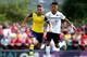 BOREHAMWOOD, ENGLAND - JULY 19: Aaron Ramsey of Arsenal tackles with Lee Angol of Boreham Wood during the pre season friendly match between Borehamwood and Arsenal at Meadow Park on July 19, 2014 in Borehamwood, England. (Photo by Jordan Mansfield/Getty