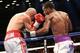BROOKLYN, NY - AUGUST 9: Lamont Peterson (White w/Purple trunks) lands a body shot to Edgar Santana (Silver w/Red trunks) during their IBF junior welterweight championship fight at the Barclays Center on August 9, 2014 in Brooklyn, New York. (Photo by Ed