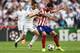 LISBON, PORTUGAL - MAY 24: Raul Garcia of Club Atletico de Madrid is challenged by Angel Di Maria of Real Madrid during the UEFA Champions League Final between Real Madrid and Atletico de Madrid at Estadio da Luz on May 24, 2014 in Lisbon, Portugal. (Ph