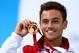 EDINBURGH, SCOTLAND - AUGUST 02: Tom Daley of England celebrates on the podium after winning the Gold medal in the Men's 10m Platform Final at the Royal Commonwealth Pool during day ten of the Glasgow 2014 Commonwealth Games on August 2, 2014 in Edinburg