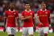 EINDHOVEN, NETHERLANDS - AUGUST 17: (L-R) Joshua Brenet, Jeffrey Bruma and Karim Rekik walk over to congratulate Memphis Depay (not in frame) of PSV after he scores the third goal of the game during the Eredivisie match between PSV Eindhoven and Go Ahea