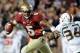 Nov 2, 2013; Tallahassee, FL, USA; Florida State Seminoles quarterback Jameis Winston (5) evades Miami Hurricanes linebacker Alex Figueroa (36) during the second half at Doak Campbell Stadium. Mandatory Credit: Melina Vastola-USA TODAY Sports