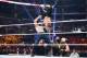 Dean Ambrose suplexes Seth Rollins into the lumberjacks.