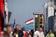 BUDAPEST, HUNGARY - JULY 25: A Hungarian national flag flaps in the wind as people walk through the paddock during practice ahead of the Hungarian Formula One Grand Prix at Hungaroring on July 25, 2014 in Budapest, Hungary. (Photo by Drew Gibson/Getty I