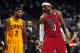 Feb 24, 2013; Miami, FL, USA; Cleveland Cavaliers point guard Kyrie Irving (left) looks over at Miami Heat small forward LeBron James (right) as Cleveland Cavaliers head coach Byron Scott (center) looks on during the second half at the American Airlines A