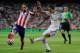 MADRID, SPAIN - AUGUST 19: Angel di Maria (R) of Real Madrid shoots past Raul Garcia of Club Atletico de Madrid during the Supercopa first leg match between Real Madrid and Club Atletico de Madrid at Estadio Santiago Bernabeu on August 19, 2014 in Madrid