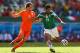 FORTALEZA, BRAZIL - JUNE 29: Giovani dos Santos of Mexico shoots and scores his team's first goal against Daley Blind of the Netherlands during the 2014 FIFA World Cup Brazil Round of 16 match between Netherlands and Mexico at Castelao on June 29, 2014 i
