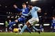 Everton's English defender John Stones (L) tries to block as Manchester City's English midfielder Raheem Sterling crosses the ball as it goes out of play during the English League Cup semi-final second leg football match between Manchester City and Everto