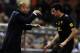 Barcelona's coach Josep Guardiola (L) speaks with midfielder Sergio Busquets during the Spanish League football match between Atletico de Madrid and Barcelona at the Vicente Calderon stadium in Madrid on February 26, 2012. AFP PHOTO/JAVIER SORIANO (Phot