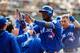 OAKLAND, CA - JULY 17: Junior Lake #48 of the Toronto Blue Jays and Andy Burns #1 celebrate with teammates in the dugout after both scored runs on a double by Josh Donaldson (not pictured) during the ninth inning against the Oakland Athletics at the Oakl