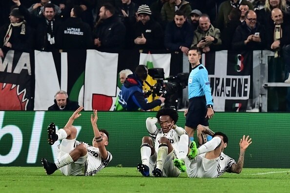 Juventus' forward from Argentina Paulo Dybala celebrates with teammates Juventus' forward from Colombia Juan Cuadrado (C) and Juventus Defender from Brazil Dani Alves after scoring a penalty during the UEFA Champions League football match Juventus vs FC P