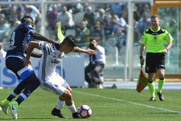 Juventus' forward from Argentina Paulo Dybala (C) fights for the ball with Pescara's midfielder from Ivory Coast Coulibaly Mamadou the Italian Serie A football match Pescara versus Juventus at Adriatico's comunal stadium, in Pescara, on April 15, 2017.  /