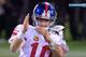 Eli Manning, barely hanging on, signals for a timeout.