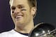 Tom Brady holds the Vince Lombardi Trophy as he stands on the podium after The New England Patriots defeated The Philadelphia Eagles in Super Bowl XXXIX at Alltel Staduim in Jacksonville, Florida. (Photo by Al Messerschmidt/Getty Images)