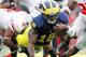 ANN ARBOR, MI - NOVEMBER 26: Denard Robinson #16 of the Michigan Wolverines dives for extra yards past C.J. Barnett #4 of the Ohio State Buckeyes at Michigan Stadium on November 26, 2011 in Ann Arbor, Michigan. Michigan won the game 40-34. (Photo by Gregory Shamus/Getty Images)
