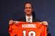 ENGLEWOOD, CO - MARCH 20: Quarterback Peyton Manning poses with his uniform after the news conference announcing his contract with the Denver Broncos in the team meeting room at the Paul D. Bowlen Memorial Broncos Centre on March 20, 2012 in Englewood, Colorado. Manning, entering his 15th NFL season, was released by the Indianapolis Colts on March 7, 2012, where he had played his whole career. It has been reported that Manning will sign a five-year, $96 million offer. (Photo by Doug Pensinger/Getty Images)