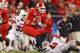 CHARLOTTE, NC - DECEMBER 27: George Bryan #84 of the North Carolina State Wolfpack makes a catch as he is hit by teammates Mike Evans #33 and Dexter Heyman #46 of the Louisville Cardinals during their game at Bank of America Stadium on December 27, 2011 in Charlotte, North Carolina. (Photo by Streeter Lecka/Getty Images)