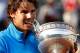 PARIS, FRANCE - JUNE 05: Champion Rafael Nadal of Spain bites the trophy following his record equalling sixth victory during the men's singles final match between Rafael Nadal of Spain and Roger Federer of Switzerland on day fifteen of the French Open at Roland Garros on June 5, 2011 in Paris, France. (Photo by Matthew Stockman/Getty Images)