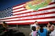 NEW YORK - JULY 4: A family eats hot dogs in front of an advertisement for the Nathan's Famous Fourth of July hot dog eating contest, to undergo later that day, on July 4, 2009 in Coney Island in the Brooklyn borough of New York City. Joey Chestnut of San Jose, California defeated Takeru Kobayashi of Nagano, Japan with eating 68 to his 64.5 hotdogs. Kobayashi won six previous competitions before tying last year with Chestnut. (Photo by Yana Paskova/Getty Images)