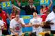 NEW YORK - JULY 4: Joey Chestnut of San Jose, California (C) and Takeru Kobayashi of Nagano, Japan (R) stuff hot dogs into their mouths during Nathan's Famous Fourth of July hot dog eating contest on July 4, 2009 in Coney Island in the Brooklyn borough of New York City. Chestnut defeated Kobayashi with eating 68 to his 64.5 hotdogs. Kobayashi won six previous competitions before tying last year with Chestnut. (Photo by Yana Paskova/Getty Images)
